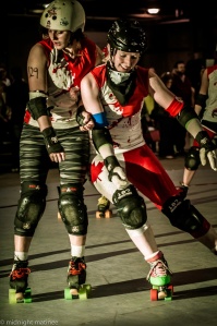 The Dolls' Rainbow Fight (right, warming up with Santilly In Yo Face) was virtually unpassable as a blocker and unstoppable as a jammer. (Photo by Joe Mac)